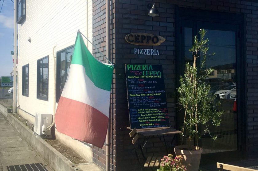 ピッツェリアチェッポの入り口と大きなイタリア国旗